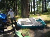 A man overlooks the bottom half of a boat in the grass.