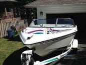 A speedboat on a trailer in a driveway.