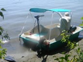 A man sits in a shored pedalboat.